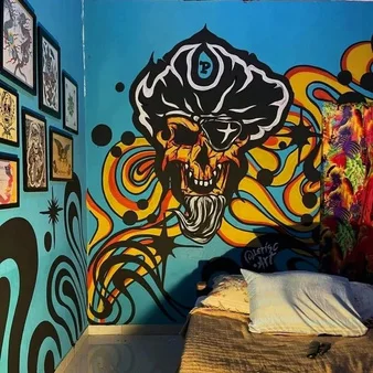 Mural com caveira e formas psicodélicas em azul, laranja e amarelo